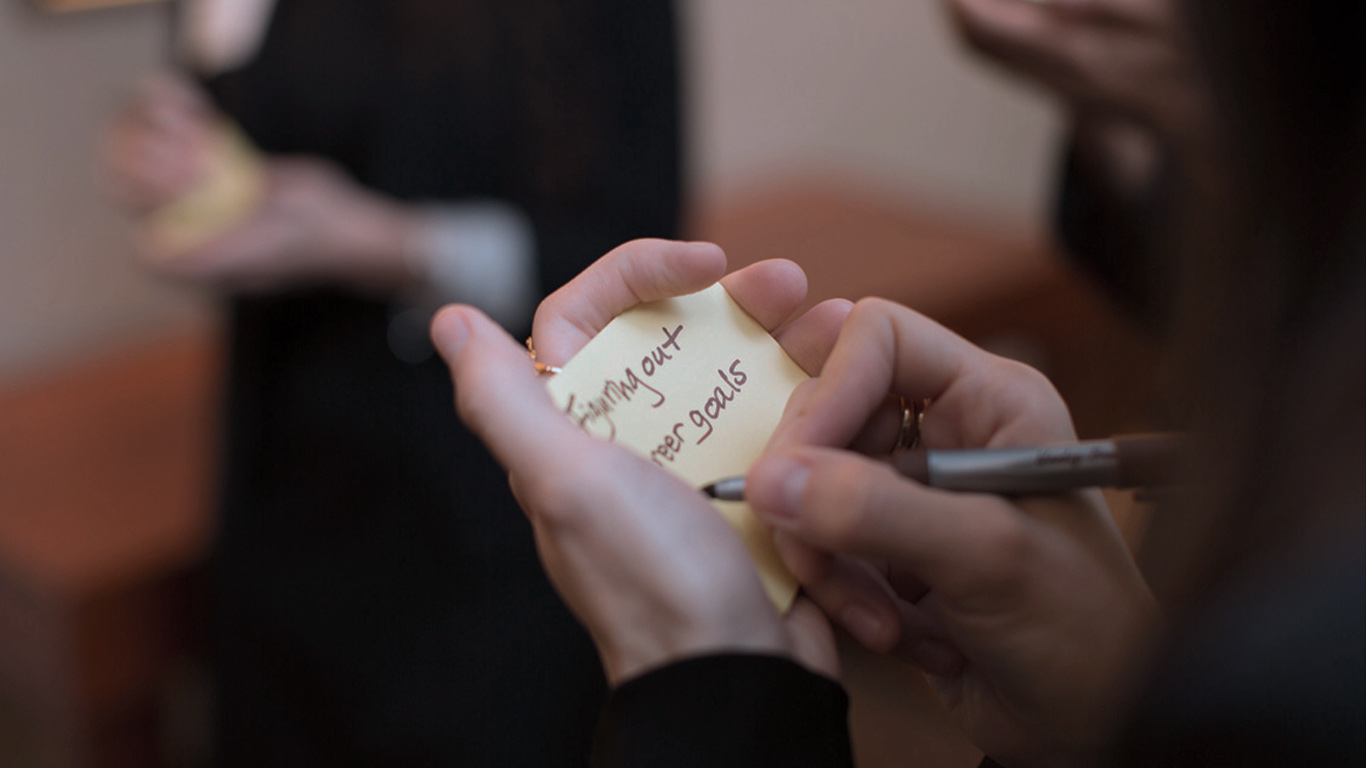 Image: Person writing on sticky note