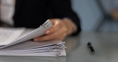 Person holding clipped stack of papers